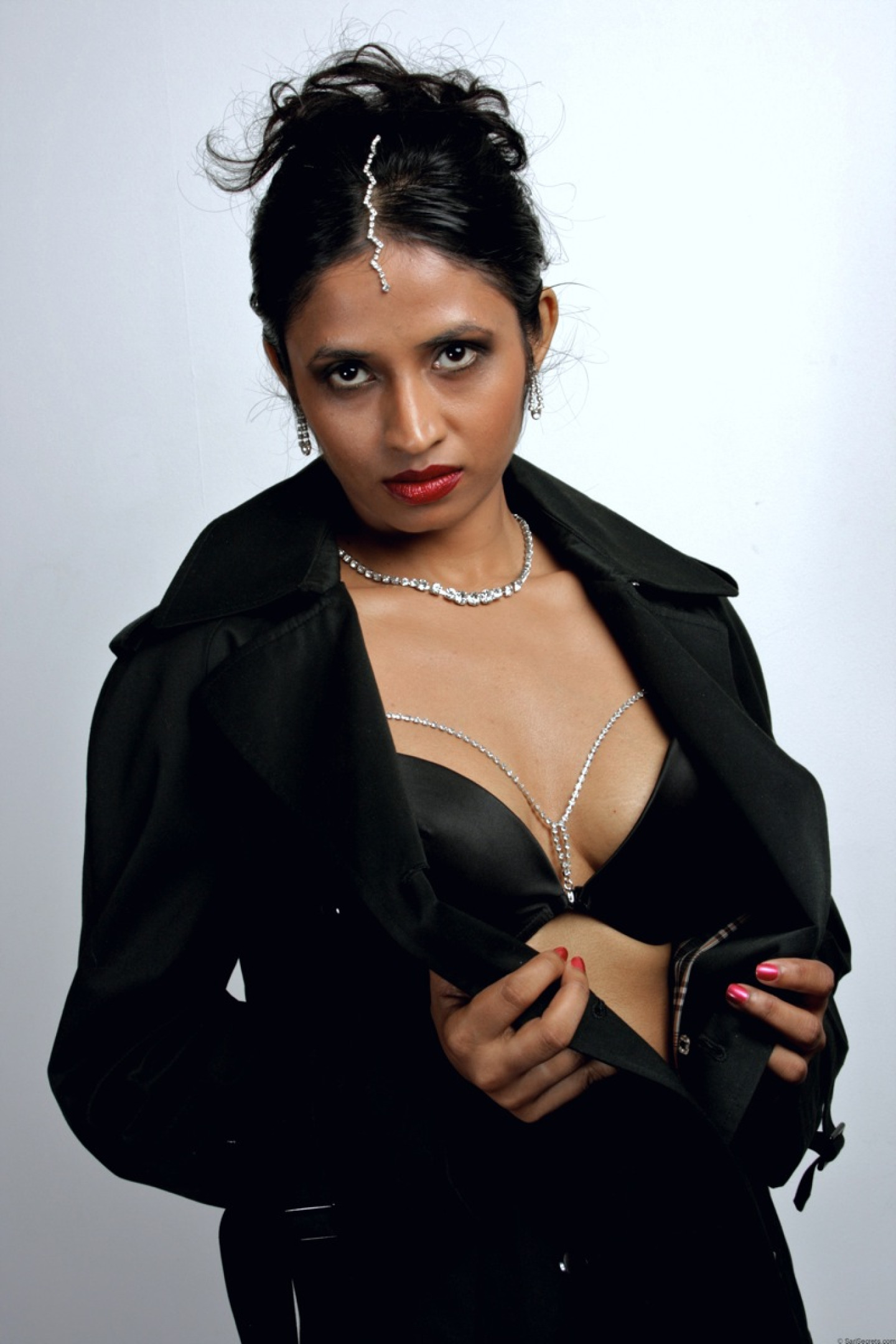 Beautiful Indian female sheds an overcoat to model in underwear and stockings
