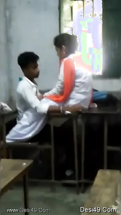 Young Lovers Kissing And Touching In Empty Classroom